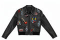 A black leather jacket by Rick Ricko featuring colorful music-themed patches and embroidered details, including a guitar, headphones, treble clefs, and cassette tapes, shown against a plain white background.