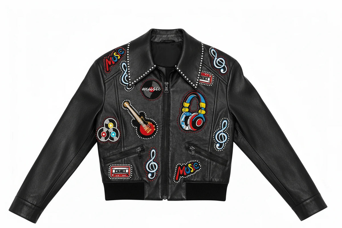 A black leather jacket by Rick Ricko featuring colorful music-themed patches and embroidered details, including a guitar, headphones, treble clefs, and cassette tapes, shown against a plain white background.